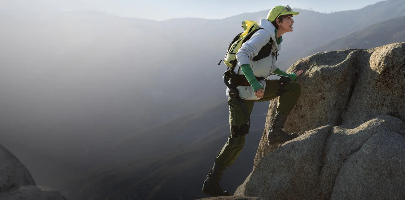 Hiker wearing a Hypershell X series exoskeleton on a rocky climb